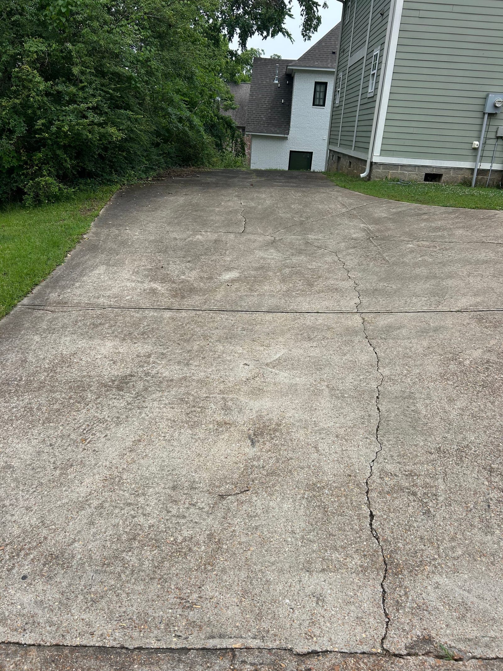 Grimy concrete pad before pressure washing