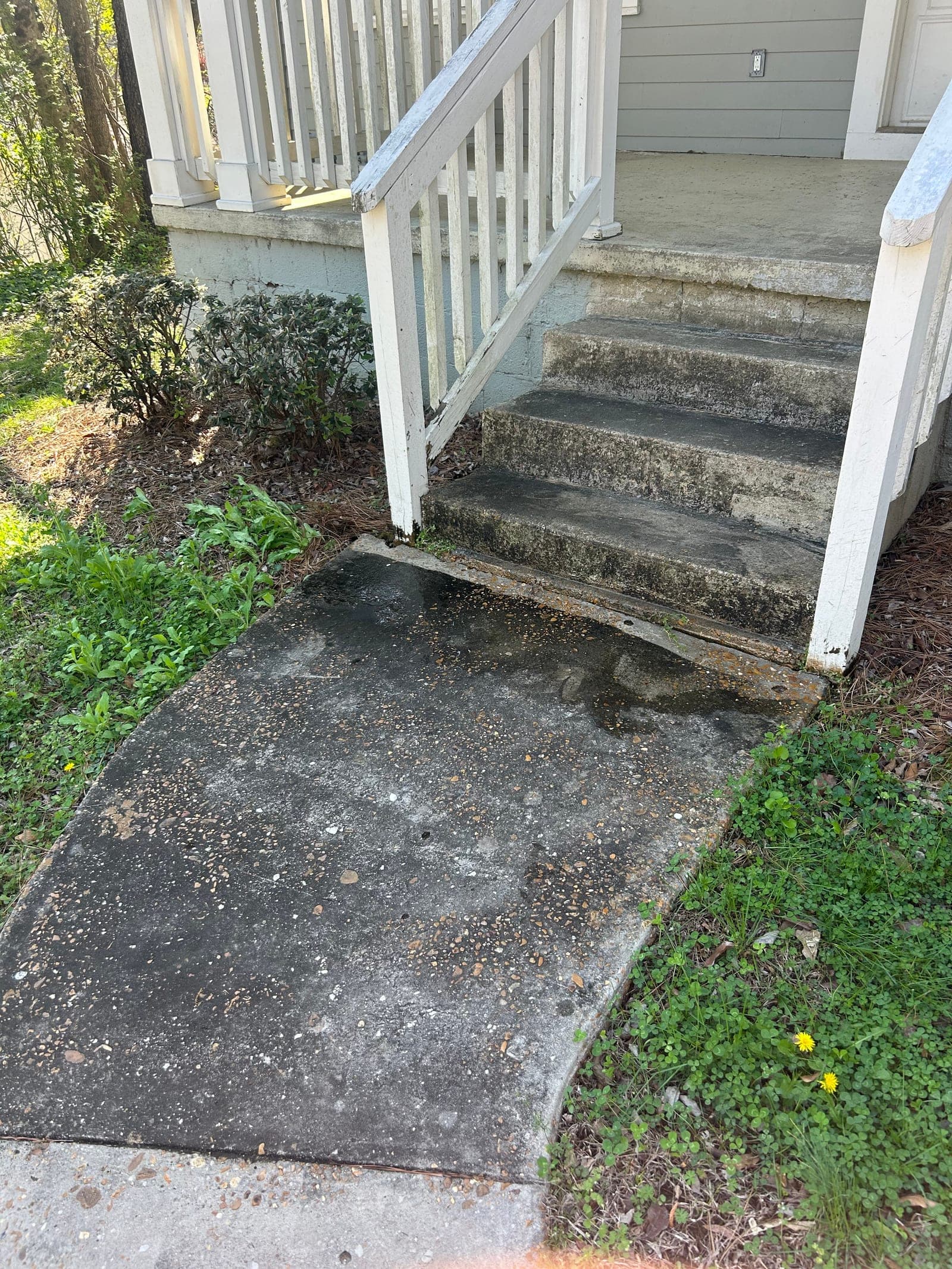 Stained concrete steps and walkway before pressure washing